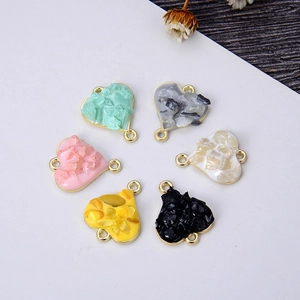 Detail of six heart-shaped pendants with colorful crushed stones in golden metal frames