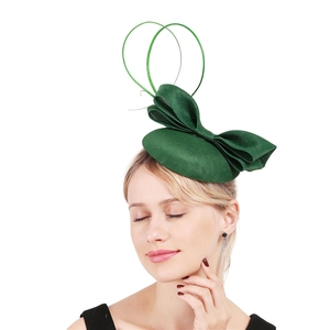 Side view of green vintage fascinator hat with bow on a model against white backdrop