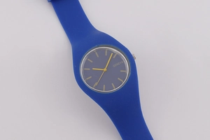 Detail of blue silicone strap and black dial with golden hands on Geneva quartz watch