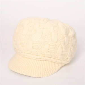 Detalle de textura de punto trenzado crema en una gorra de punto cálida de invierno