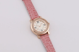 Detailed macro of rose gold quartz watch with pink crocodile leather strap and Roman numerals