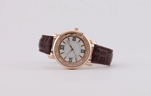 Detail of rose gold watch with crystal bezel and brown leather crocodile strap