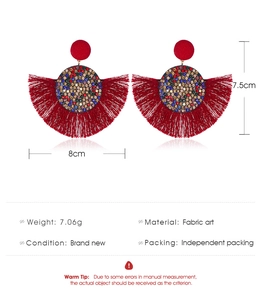 Vista macro de pendientes bohemios con flecos rojos con detalles de strass y medida 8 cm
