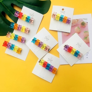 Set of 7 colorful acrylic jelly bear hair clips displayed on a white card background