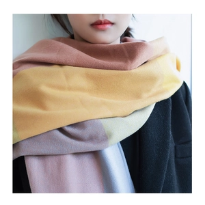 Thick warm plaid scarf with soft pink yellow blue blocks shown on a female model