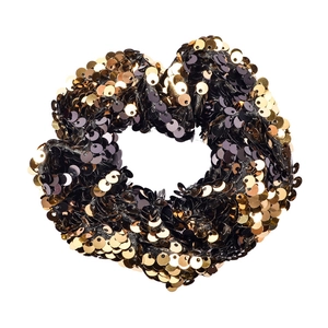 Detail of a round elastic hair tie covered in sparkling gold and black mermaid sequins