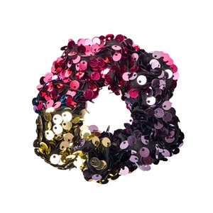Macro detail of mermaid sequin hair tie showing purple and gold reversible texture