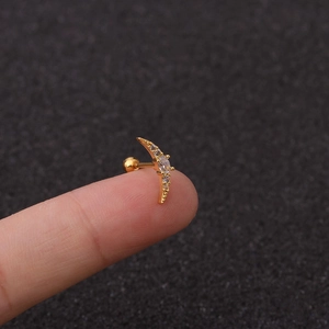 Detailed close-up of golden crescent moon and star stud earring with clear zircon crystals