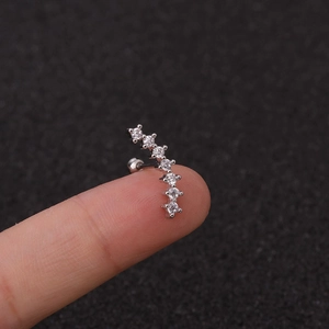 Nahaufnahme eines gebogenen silbernen Ohrsteckers mit Zirkonia-Besatz am Finger zur Größenansicht