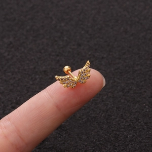 Golden angel wing zircon stud earrings with screw back displayed on a fingertip
