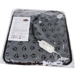 Détail du tapis chauffant gris pour animaux avec empreintes, contrôleur et manuel