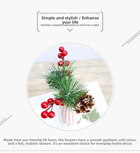 Artificial Christmas pine needles with red berries and pine cones in a pink ceramic vase