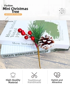 Macro detail of artificial Christmas pine branch with red berries and snowy pinecone