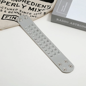 Punk style faux leather bracelet featuring three rows of silver cone rivets and snap buttons