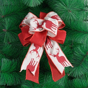 Red reindeer printed linen Christmas bow topper on green pine needle background