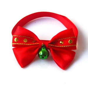 Detail of red Christmas pet bow tie with green bell and golden sequin trim edges