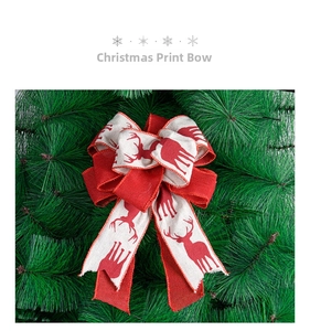 Close-up of rustic linen Christmas bow with red reindeer print on green pine needles