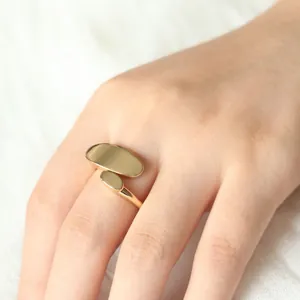 Minimalist 18K gold geometric oval pea ring shown on finger with polished finish