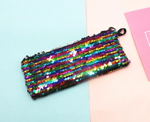 Detailed top view of rainbow sequin pencil case with smooth zipper on blue background