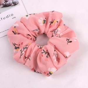 Close-up of pink floral scrunchie showing detailed chiffon fabric texture and patterns