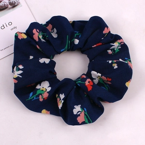Close-up of navy blue floral fabric scrunchie with high elastic ruffled texture
