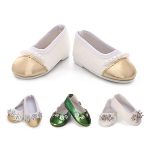 Macro detail of 7.5cm doll shoes with pearls and gold accents on white background