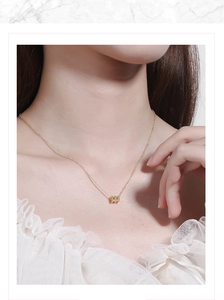 Close-up of golden cylinder pendant and delicate thin chain on elegant woman's neckline