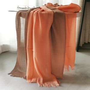 Detailed view of linen blend scarf with orange and brown gradient tones and tassels