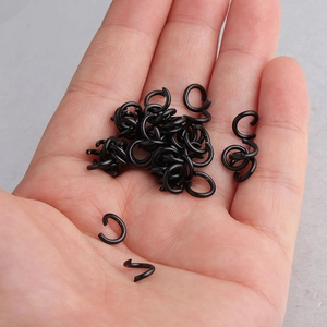 Black stainless steel open jump rings for DIY jewelry making held in a palm