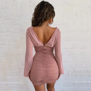 Detail view of pink long sleeve bodycon dress with ruffled edges and V-shaped backless design