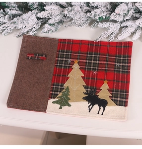 Detail of Christmas placemat with red plaid patchwork and reindeer silhouette embroidery