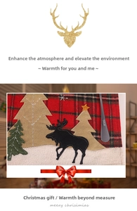 Close-up of Christmas table mat with red-green plaid fabric and embroidered reindeer detail