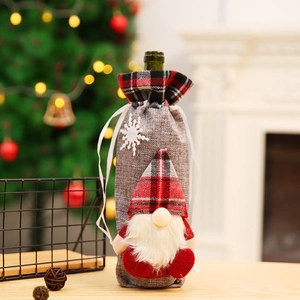 Grey burlap Christmas gnome wine bottle cover with red plaid trim and white snowflake decor