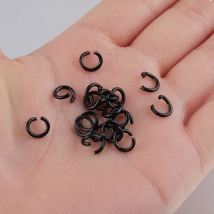 Bulk black stainless steel jump rings for DIY jewelry making held in a person's hand