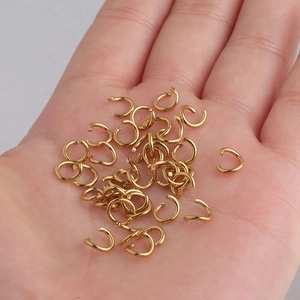 Golden stainless steel open jump rings for DIY jewelry making shown in a palm for scale