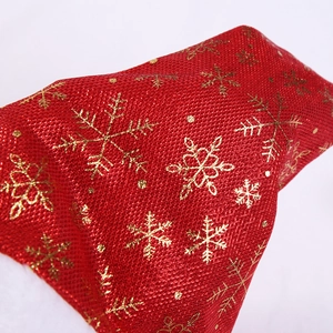 Detailed macro view of red fabric with gold snowflake patterns and white plush trim