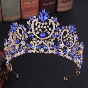 Ornate gold Baroque bridal crown with deep blue rhinestones on vintage background