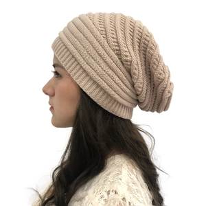Close-up of the fine knit texture and slouchy design of a thick beige beanie for women
