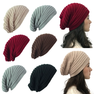 Detail view of multicolored knitted beanies and model wearing a slouchy knit hat