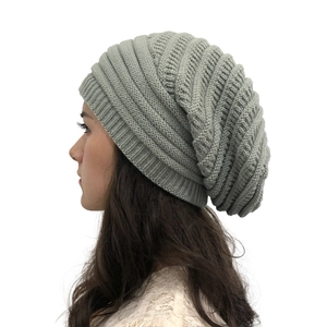 Detail view of women's slouchy knit beanie in grey-green twill fabric on model