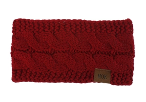 Macro detail of red cable knit headband showing thick texture and brown leather label