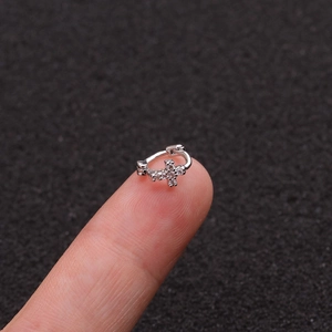 Silver cross hoop earring with cubic zirconia on fingertip for size reference