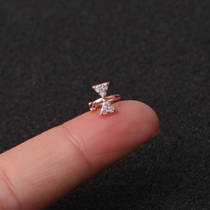 Close-up of rose gold bow-shaped cartilage clip with sparkling clear zircon stones