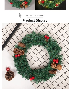 Détail d'une couronne de Noël verte avec pommes de pin et baies rouges sur tissu écossais
