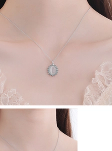 Detail of flower necklace with cat eye stone pendant worn on woman's neck