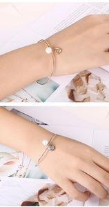 Detailed comparison of silver and rose gold open bracelets with pearls and heart charms