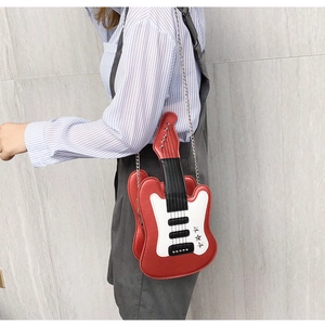 Detail shot of a red guitar-shaped crossbody bag with silver star and chain strap
