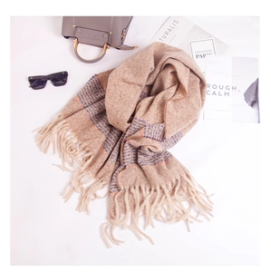 Close-up of soft cashmere-feel striped scarf with long tassels and camel check pattern