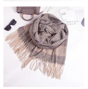 Close-up of thick knit scarf with fringe edge and subtle orange and purple stripes