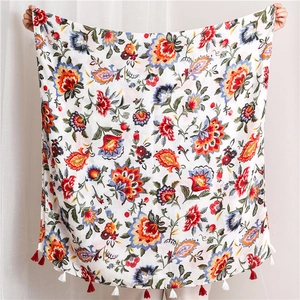 Detail of bohemian floral print scarf with vibrant patterns and ethnic tassel edge